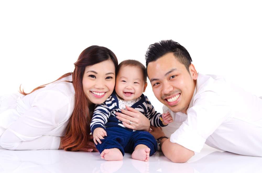 Asian parent and their six months old cheerful baby
